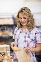 Smiling blonde woman taking a bread