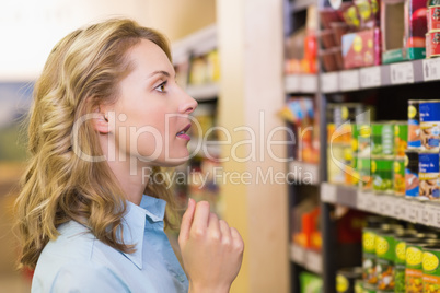 Pretty blonde woman looking at shelves