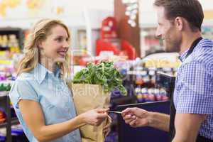 Woman at cash register paying with credit card