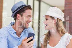 Cute couple discussing over smartphone
