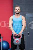 Muscular man lifting a kettlebell