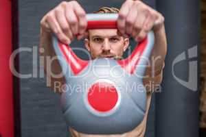 Muscular man lifting a kettlebell