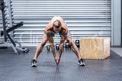 Muscular man doing body stretching