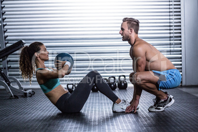 Muscular couple doing abdominal ball exercise