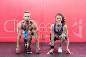 Muscular couple doing body stretching