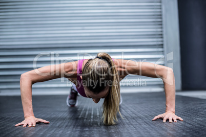 Muscular woman doing push ups