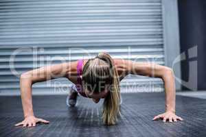 Muscular woman doing push ups