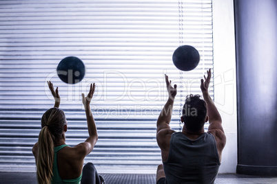 Muscular couple throwing ball in the air