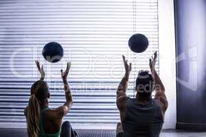 Muscular couple throwing ball in the air