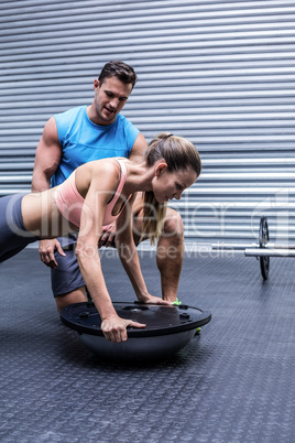 Muscular woman doing bosu ball exercises