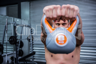 Muscular man lifting a kettlebell