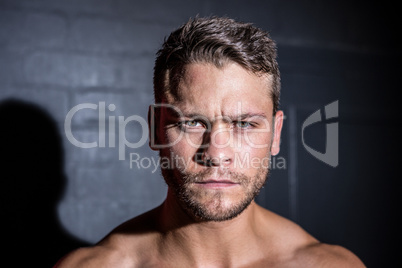 Portrait of serious muscular man looking at camera