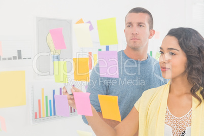 Concentrated coworkers pointing sticky notes