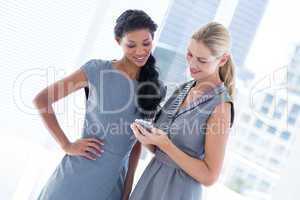 Businesswoman showing her phone to her colleague