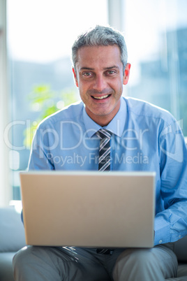 Happy businessman using laptop computer