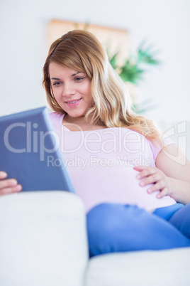 Happy pregnant woman using tablet