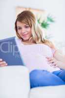 Happy pregnant woman using tablet