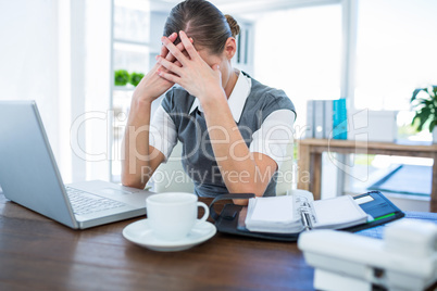 Depressed businesswoman with hands on head