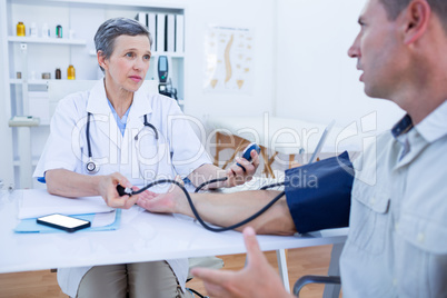 Doctor checking blood pressure of her patient