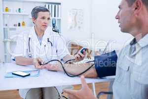 Doctor checking blood pressure of her patient