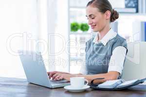 Happy businesswoman working on laptop computer