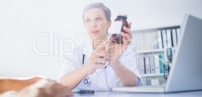 Female doctor holding a box of pills