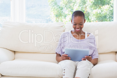 Happy smiling woman using digital tablet on couch