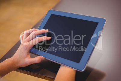 Pretty girl using a small tablet at table