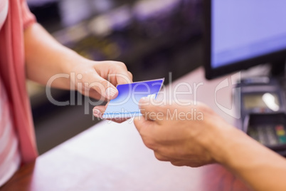 Woman at cash register paying with credit card