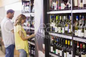 Pretty woman and handsome buying a wine bottle