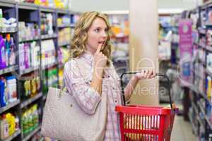 Side view of a pretty blonde woman having a shopping bag and loo