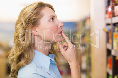 Pretty blonde woman looking at shelves