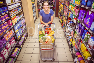 Pretty woman pushing trolley in aisle