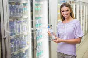 Portrait of a pretty smiling blonde woman buying water