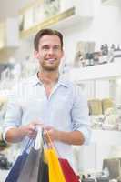 A smiling man with shopping bags