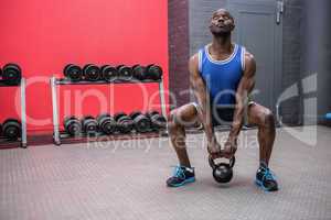 Muscular man lifting a kettlebell