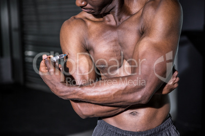 Young Bodybuilder injecting something into his arm