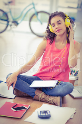 Young creative businesswoman listening to music
