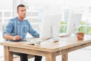 Young creative businessman drawing on graphic tablet