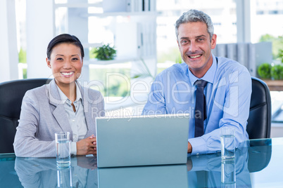 Happy business people working on laptop computer