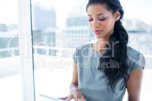 A focused businesswoman using digital tablet