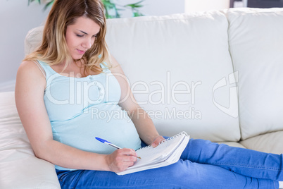 Pregnant woman writing down some notes