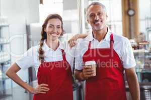 Two baristas smiling at the camera