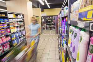 A woman walking in aisle with her trolley