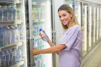 A pretty smiling blonde woman buying water