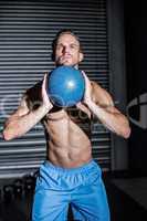 Muscular man doing ball exercise