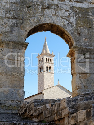 Bell tower of Saint Anthony Church in Pula, Croatia seen through the arc of Pula Amphitheater