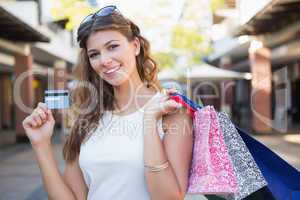Portrait of smiling woman with shopping bags and credit card loo