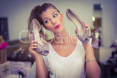 Woman holding high-heeled sandals and having fun