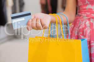 Woman with shopping bags paying by credit card